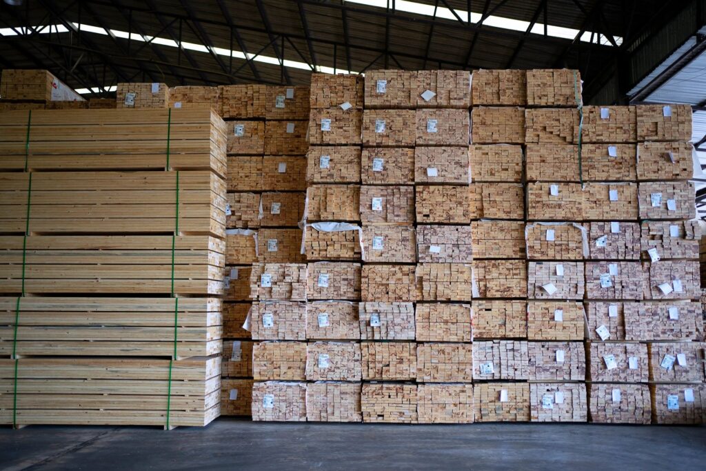 Blue collar workers are working at wooden pallets factory.